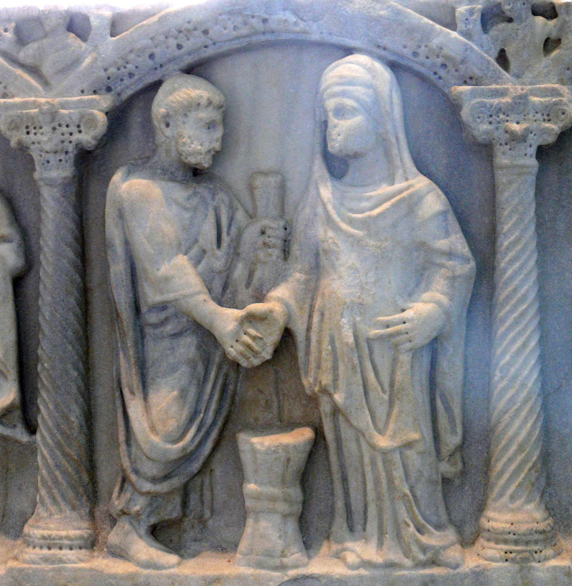Roman couple joining hands (dextrarum iunctio); the bride's belt may show the knot symbolizing that the husband was "belted and bound" to her, which he was to untie in their bed (4th century sarcophagus).