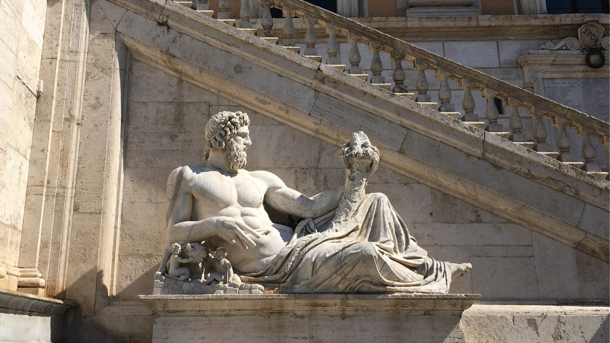 Ancient Roman Statue of the Tiber River God (Tiberinus) in the Piazza del Campidoglio, designed by Michelangelo, in Rome, Italy at the base of stone steps leading to the first floor.