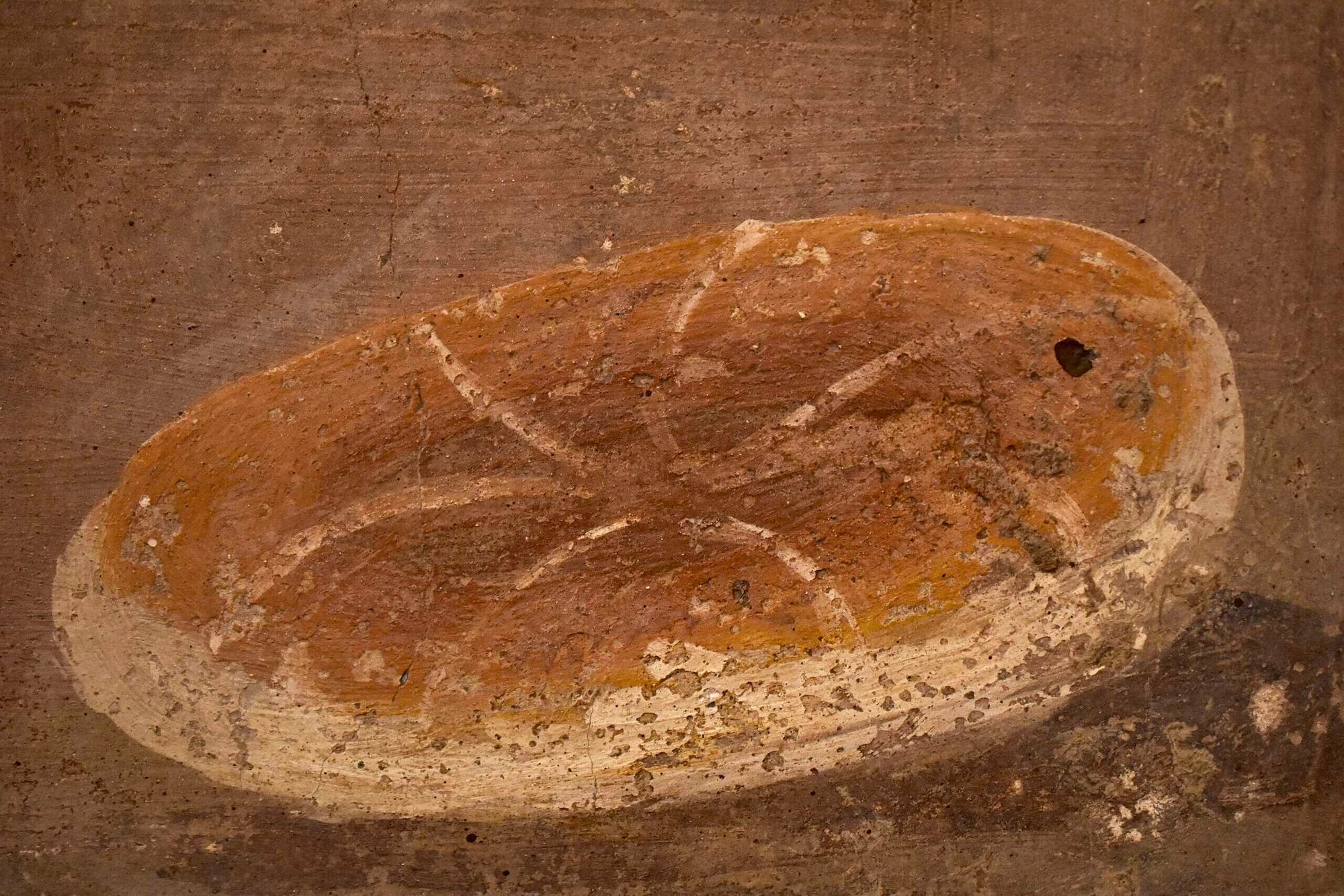 A detail from a fresco in Herculaneum, showcasing a Roman loaf of bread