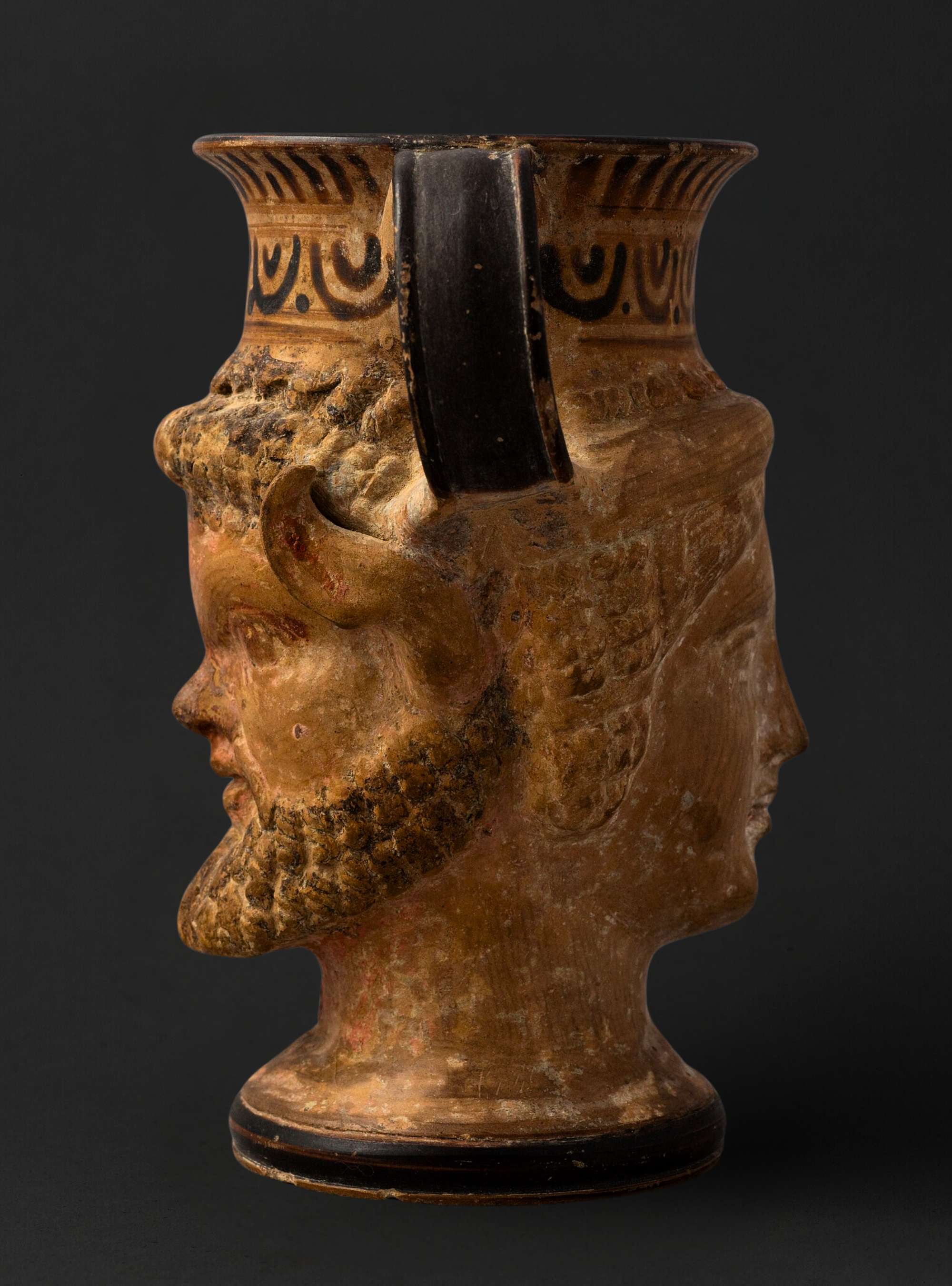 A vessel resembling the form of God Janus (Janiform) in the shape of Satyr and menad heads 